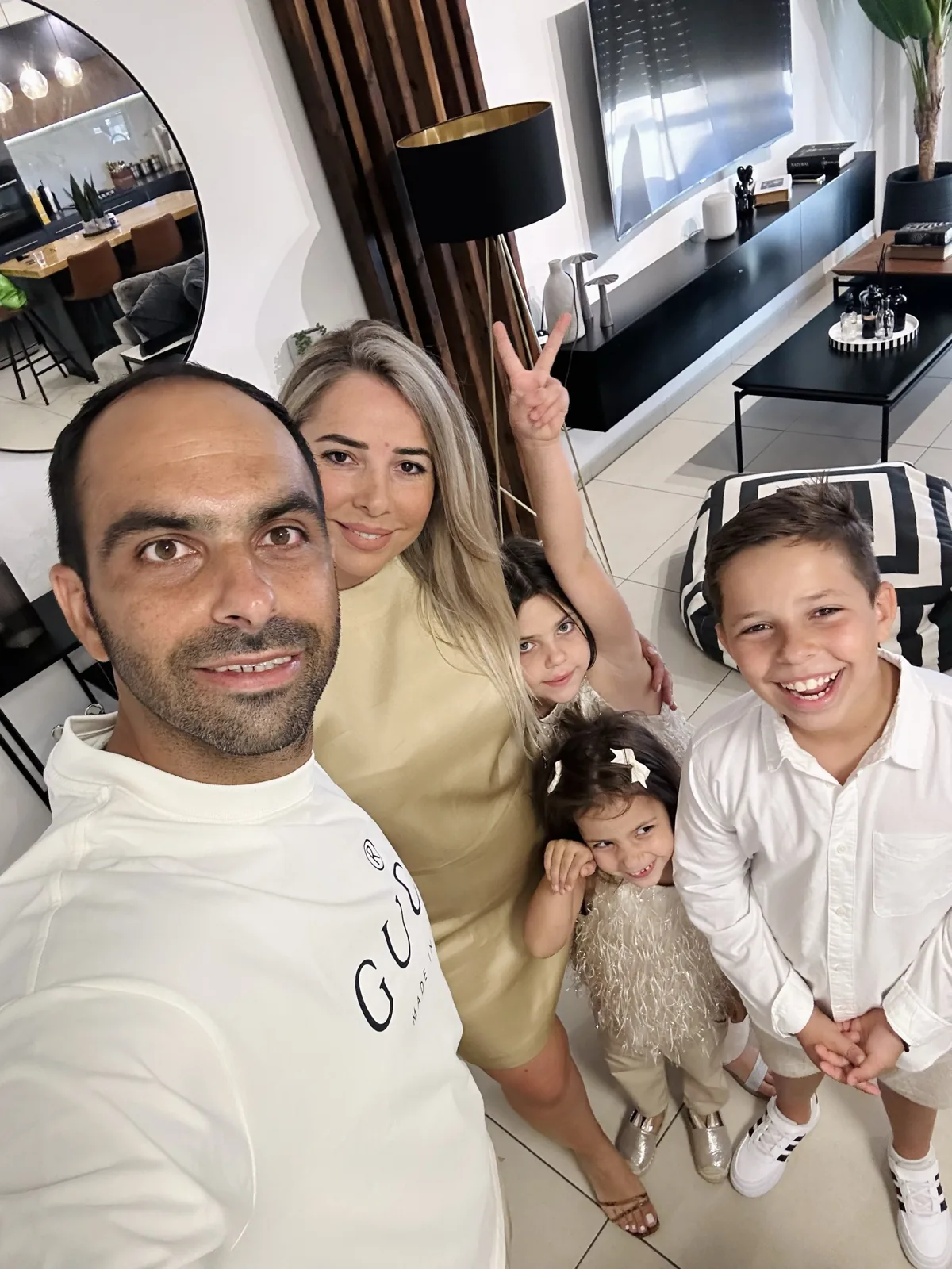 ישראל אוחנה עם אשתו ושלושת ילדיהם בסלון הבית בשדרות